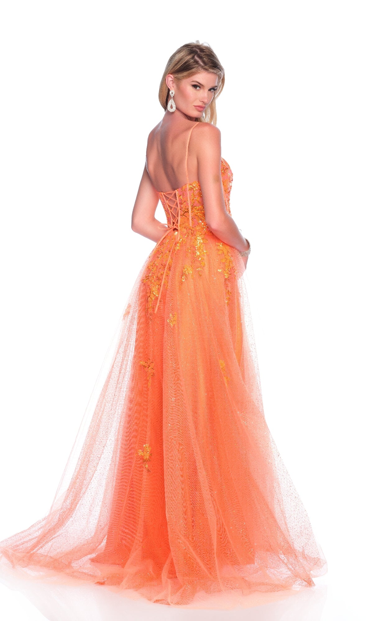 A woman stands against a white background wearing the Long Orange Prom Dress: Dave and Johnny 12008, featuring a strapless corset bodice, floral embellishments, and an A-line tulle skirt.